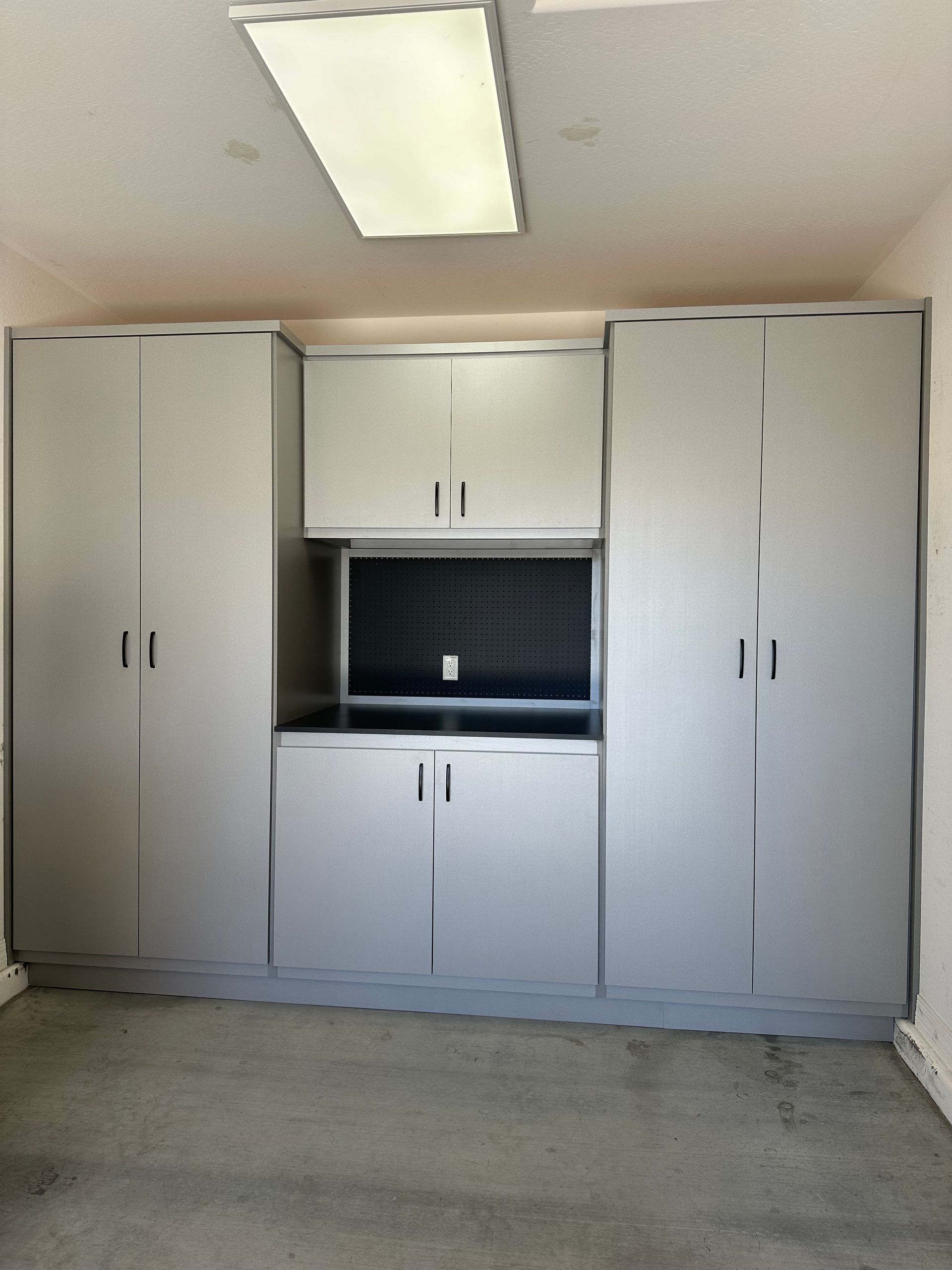 A workbench with white cabinets and a sink