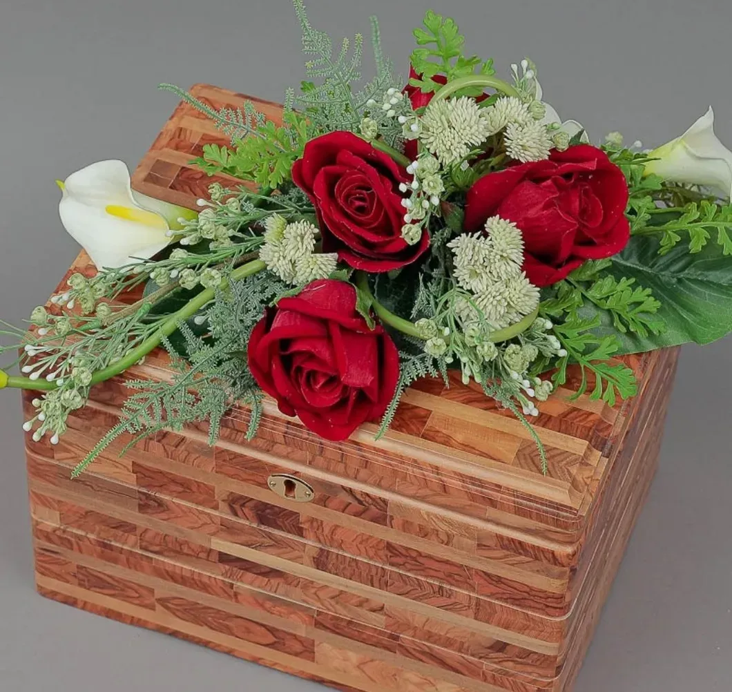 Rose rosse e fiori bianchi disposti in un bouquet all'interno di una scatola di legno.