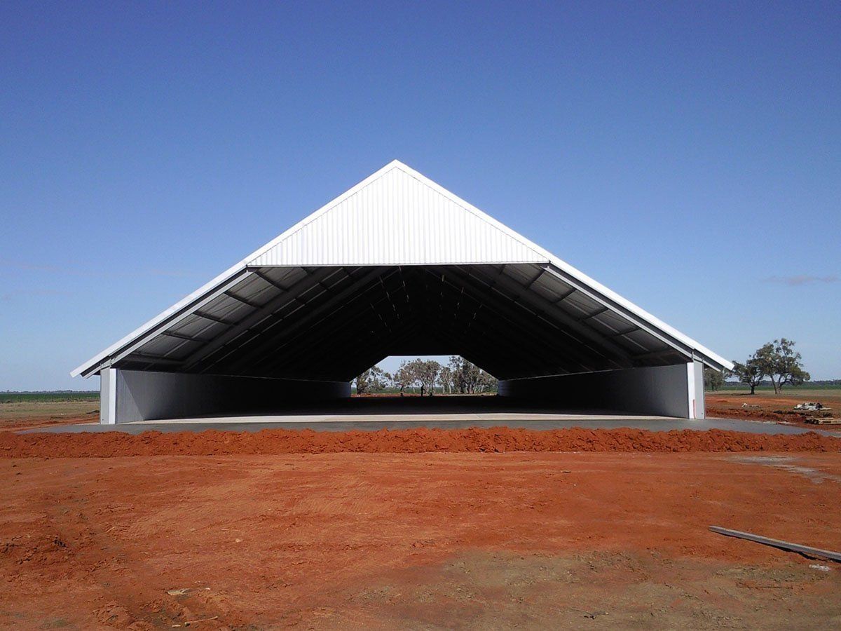 A large white triangle shaped building with a blue sky in the background