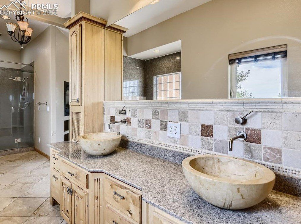 A bathroom with two sinks and a large mirror.