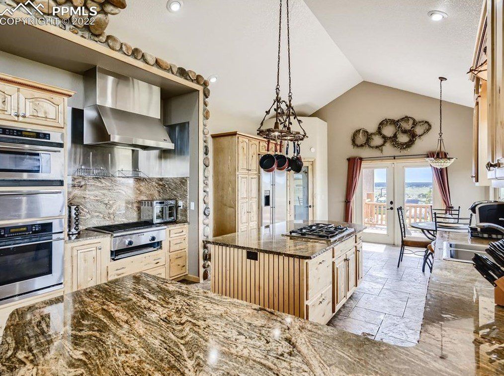 A kitchen with granite counter tops and stainless steel appliances.