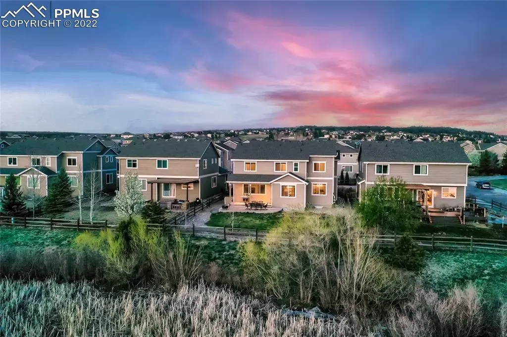An aerial view of a row of houses with a sunset in the background.