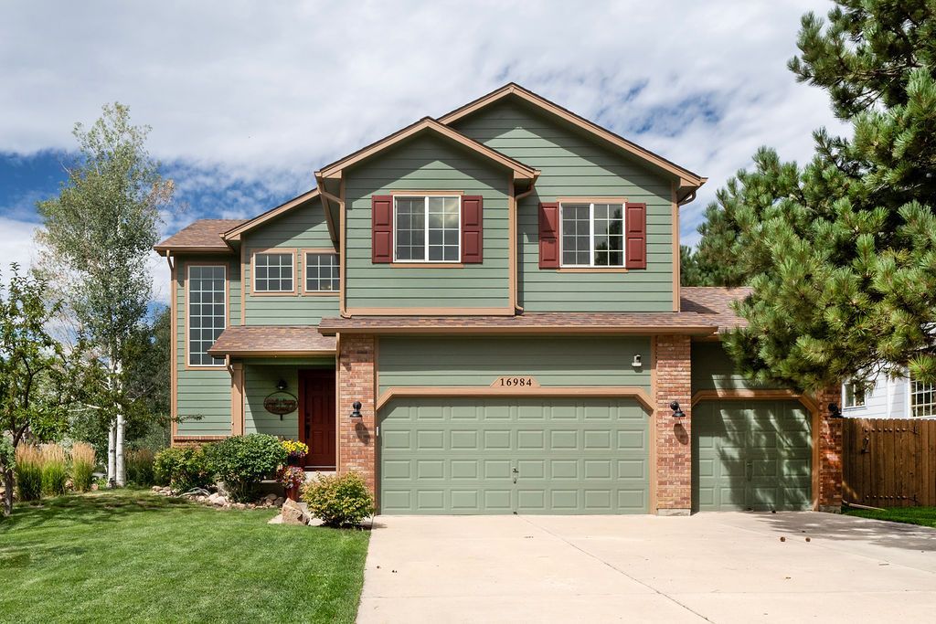 A large house with a green siding and shutters