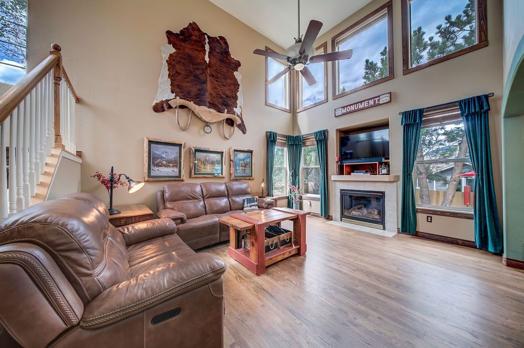 A living room with a couch , chair , coffee table and fireplace.