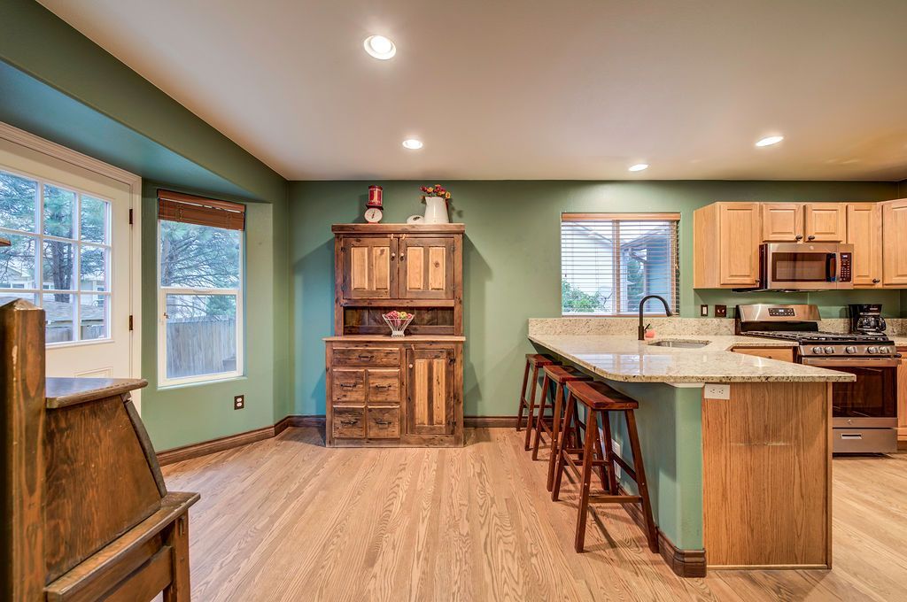 A kitchen with green walls and wooden cabinets and a large island.