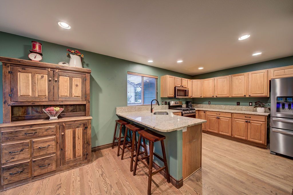 A kitchen with wooden cabinets , stainless steel appliances , and a large island.