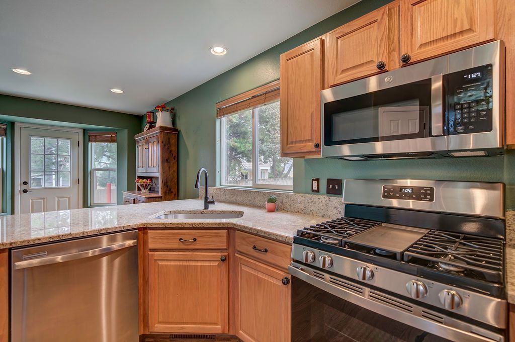 A kitchen with stainless steel appliances and wooden cabinets.