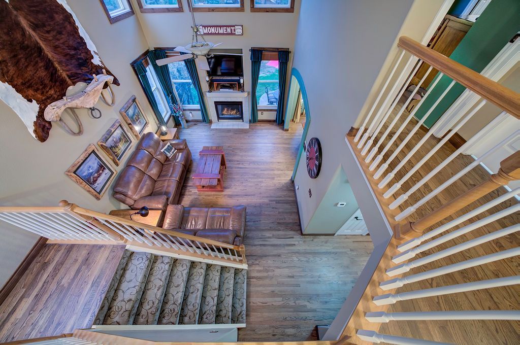 An aerial view of a living room and stairs from the second floor.
