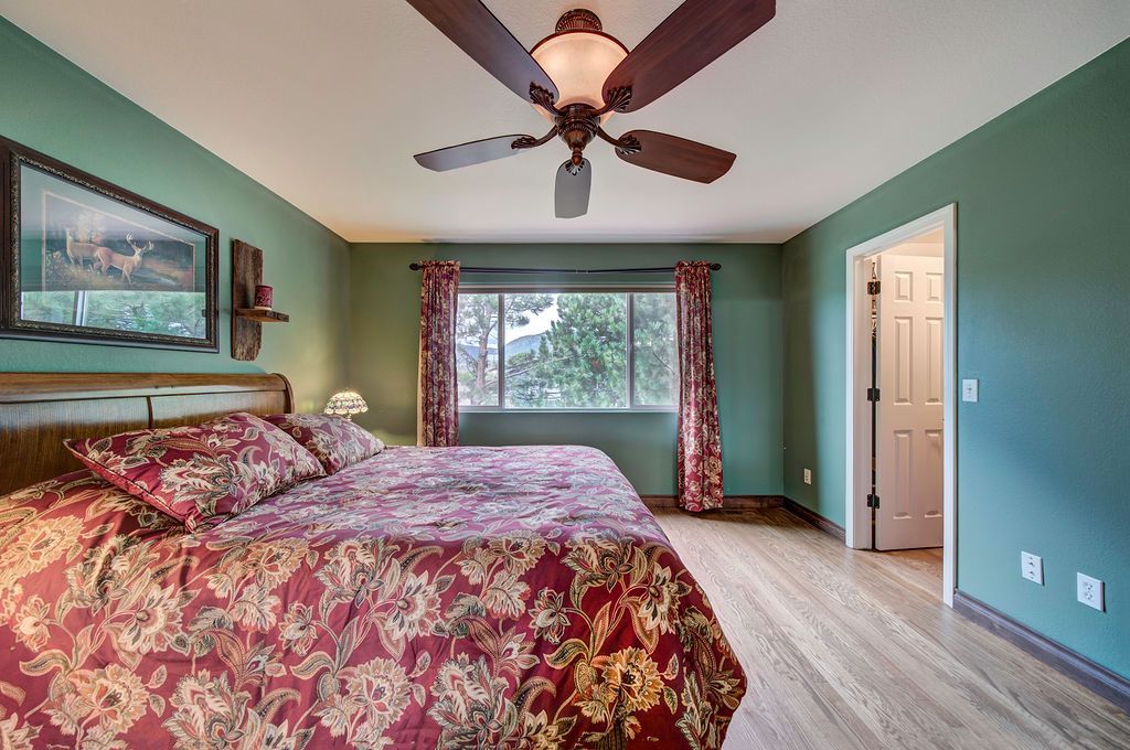 A bedroom with a bed , ceiling fan , and window.
