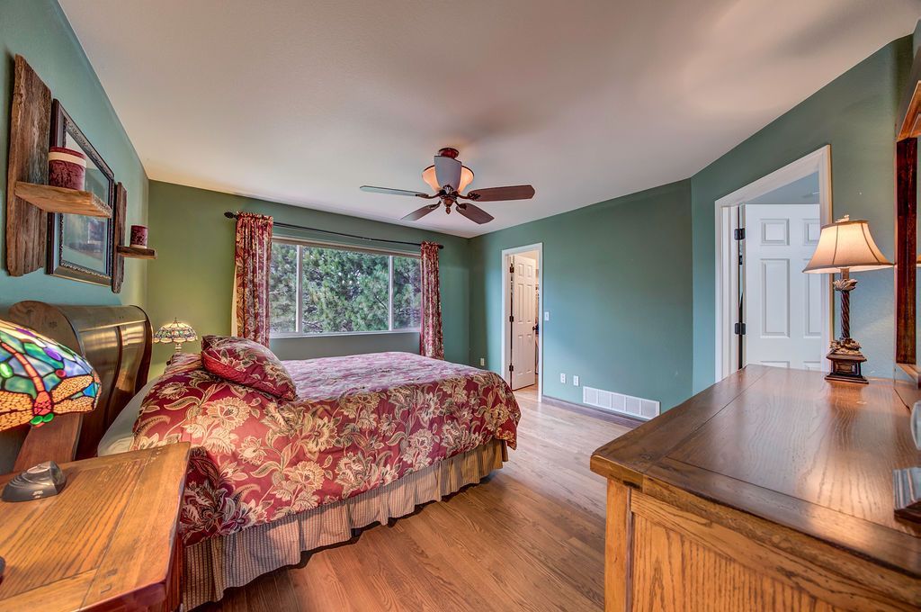 A bedroom with a large bed and a ceiling fan.