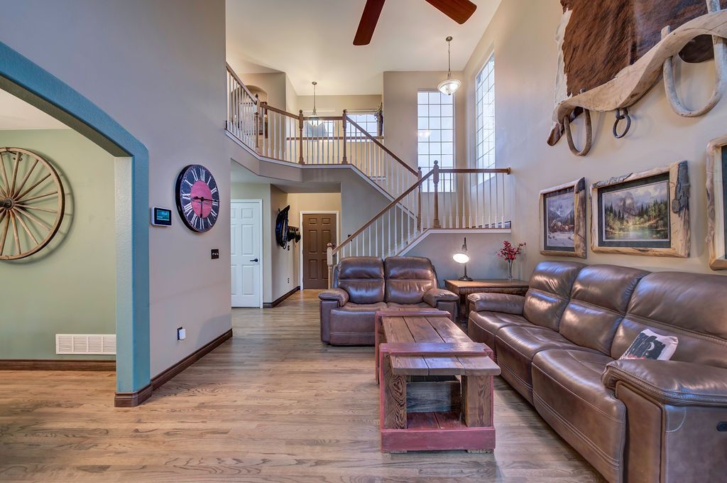 A living room with a lot of furniture and a staircase.