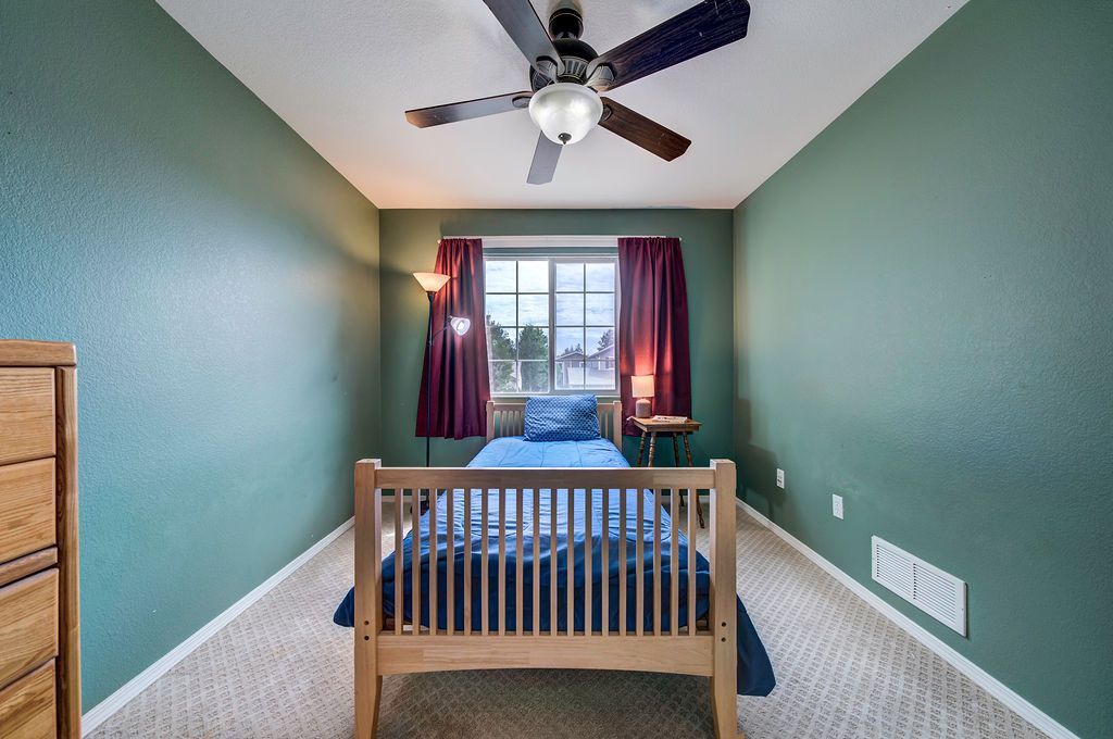 A bedroom with a bed and a ceiling fan