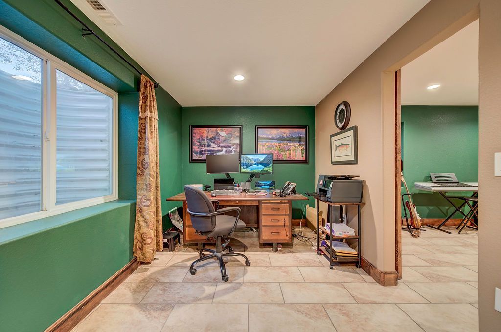 A home office with green walls and a desk and chair.