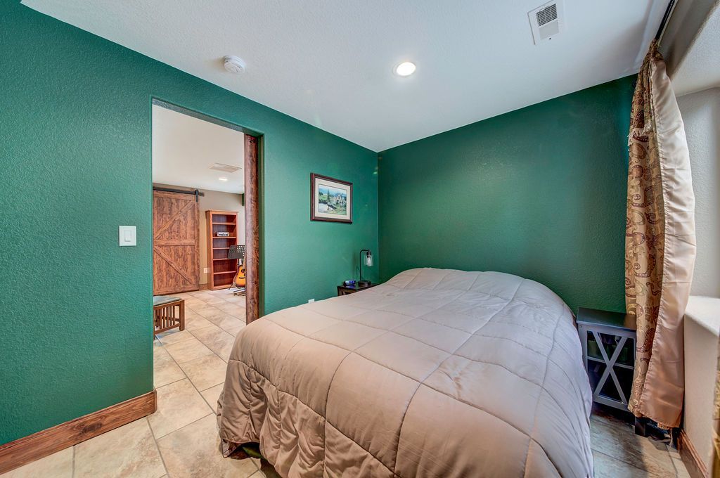 A bedroom with green walls and a large bed.