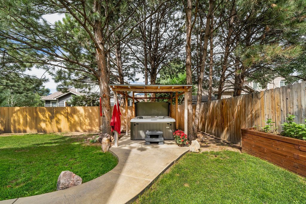 There is a hot tub in the backyard surrounded by trees.