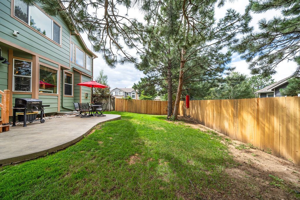 There is a wooden fence in the backyard of a house.