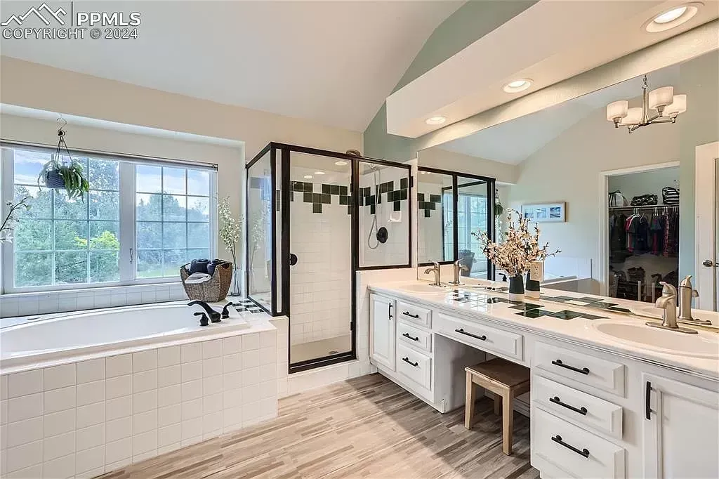 A large bathroom with a tub , sink , and mirror.