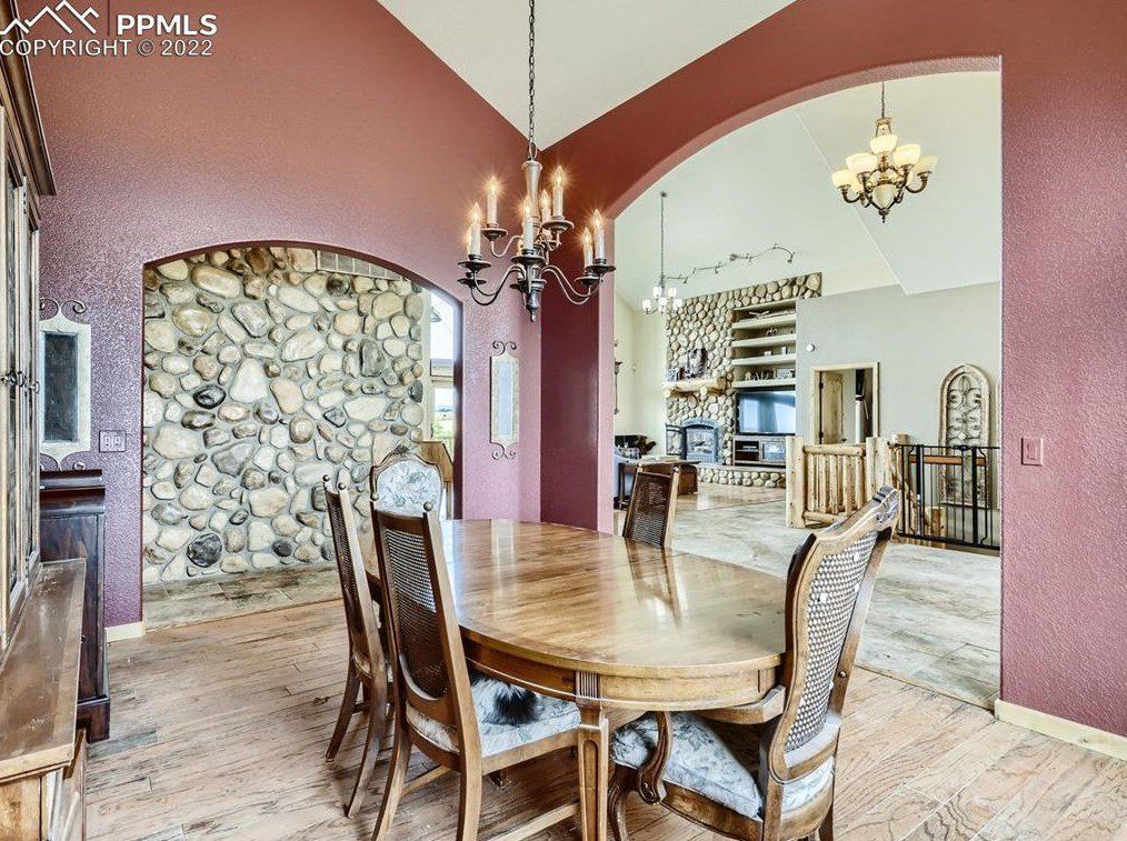 A dining room with a table and chairs and a chandelier.