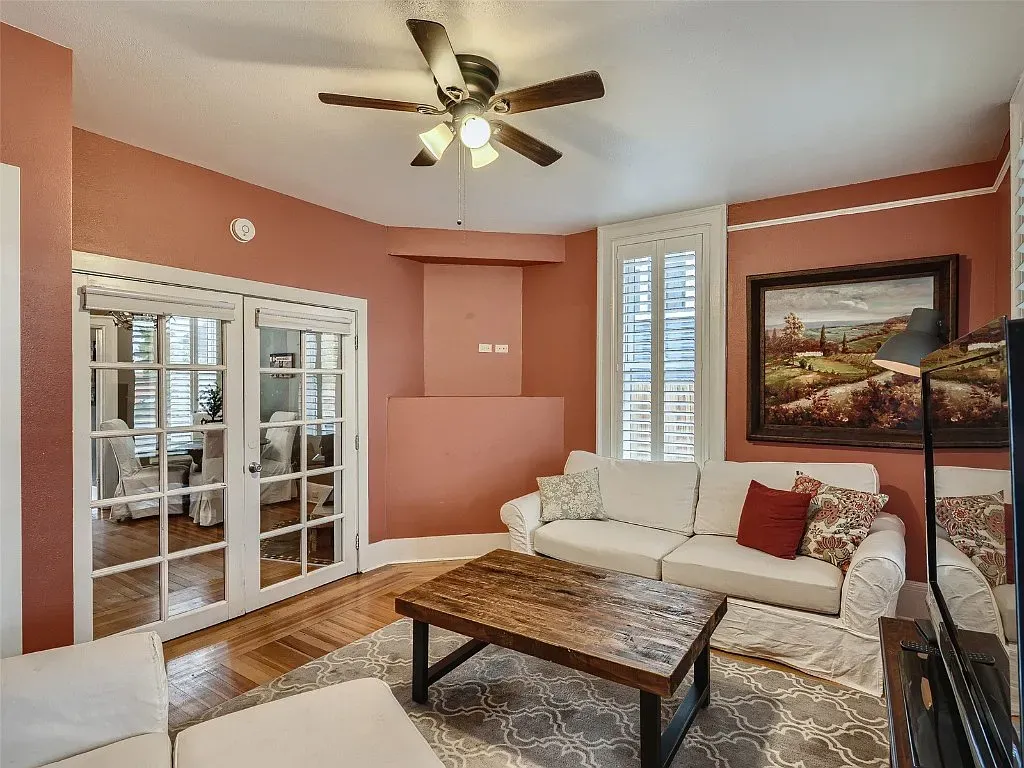 A living room with a couch , coffee table , and ceiling fan.