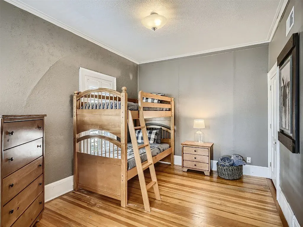 A bedroom with a bunk bed and a dresser.