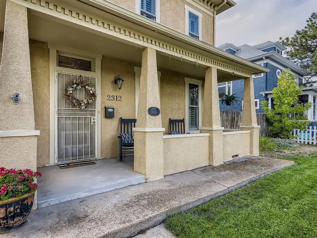 The front porch of a house with a wreath on the door.