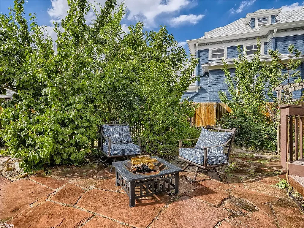 A patio with a table and chairs in front of a house.