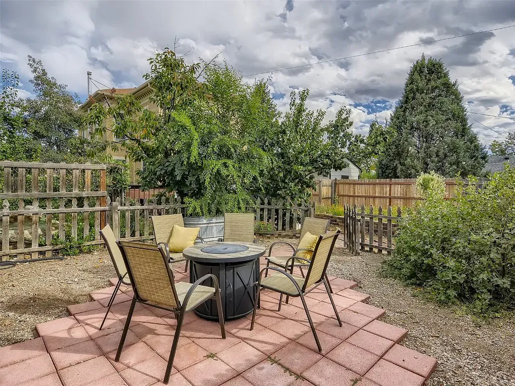 A patio with a table and chairs and a fire pit.