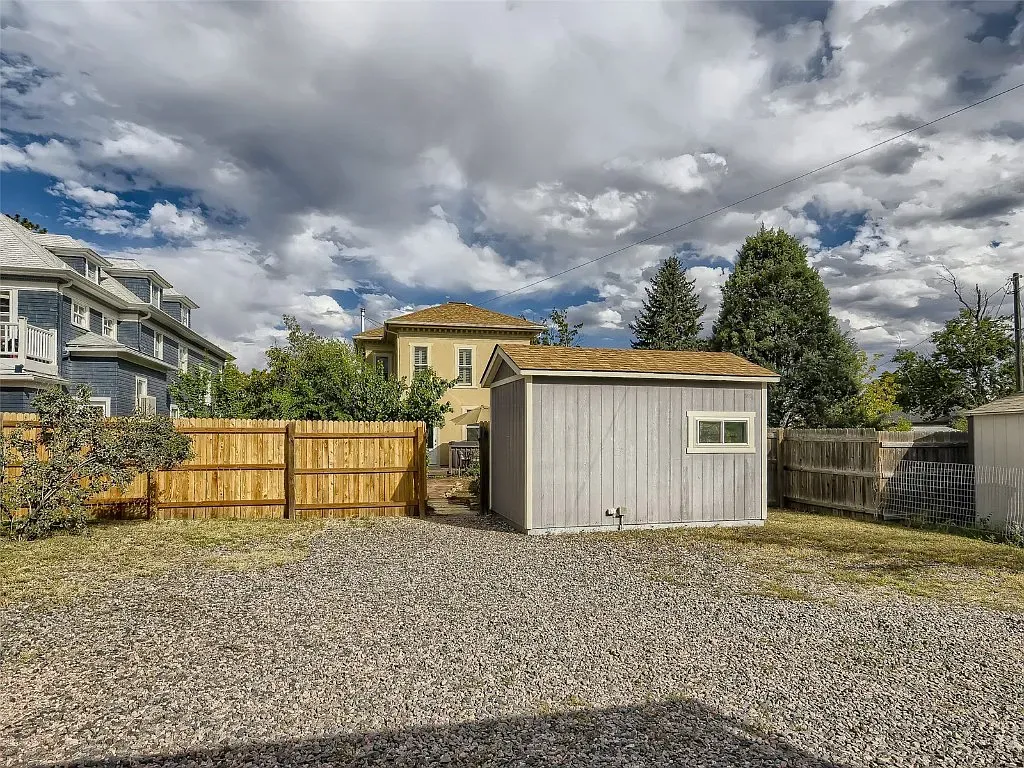 There is a shed in the backyard of a house.