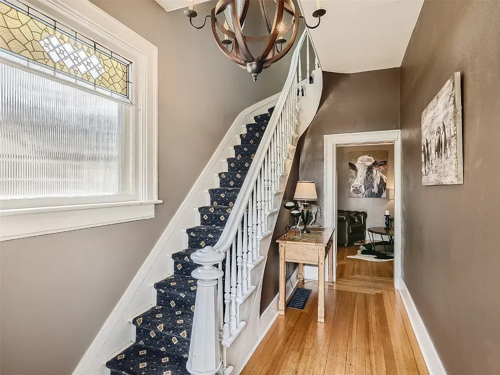 A hallway with stairs leading up to the second floor of a house.