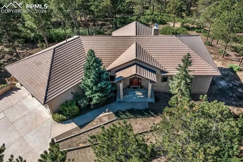An aerial view of a large house surrounded by trees