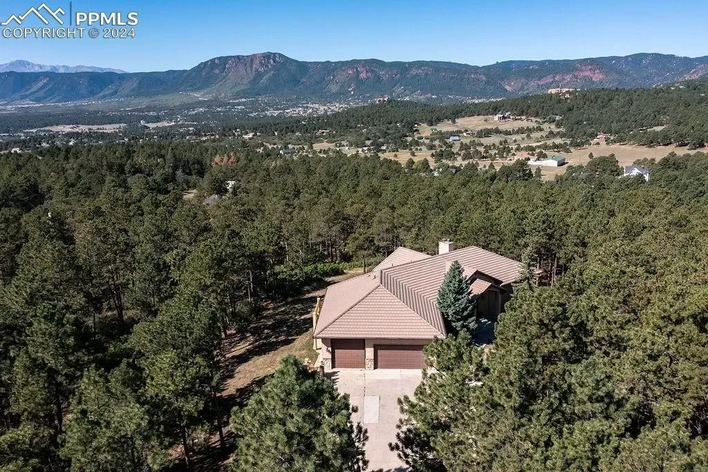 An aerial view of a house in the middle of a forest
