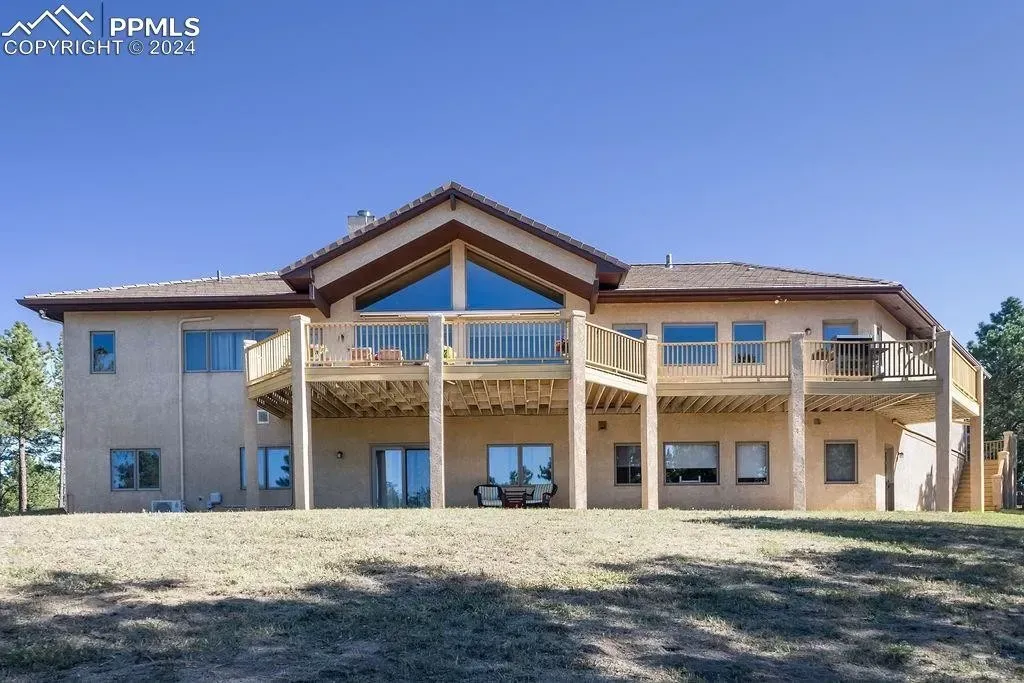 A large house with a lot of windows is sitting on top of a hill.