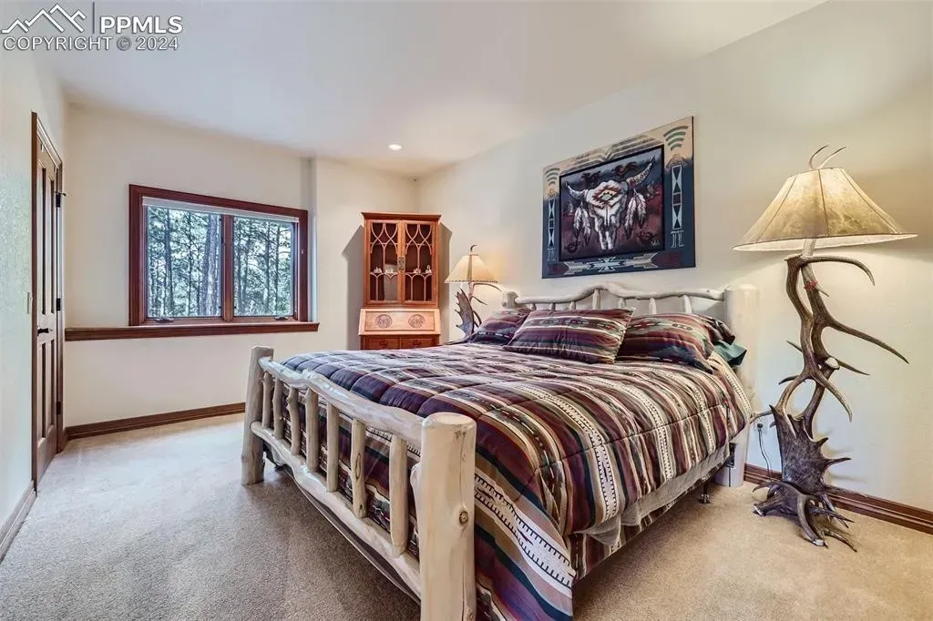 A bedroom with a king size bed and a lamp
