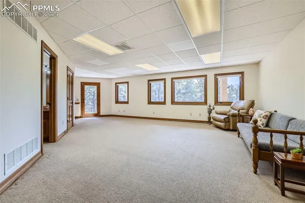 An empty room with a couch and chairs in it.