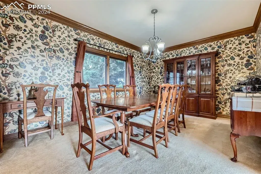 A dining room with a table and chairs and a hutch.