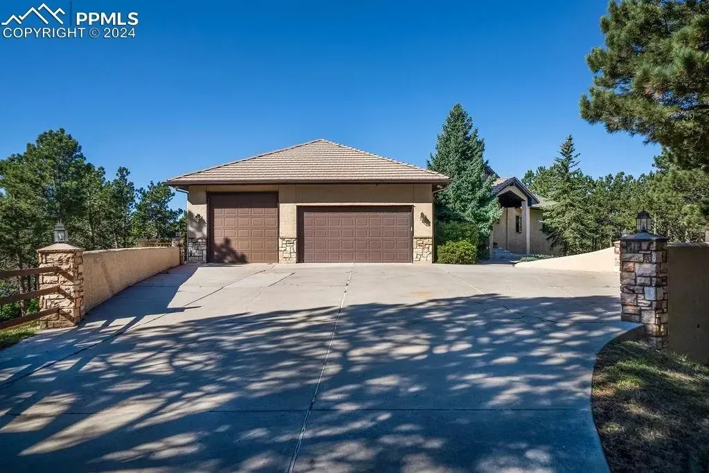A large house with two garages and a driveway leading to it.