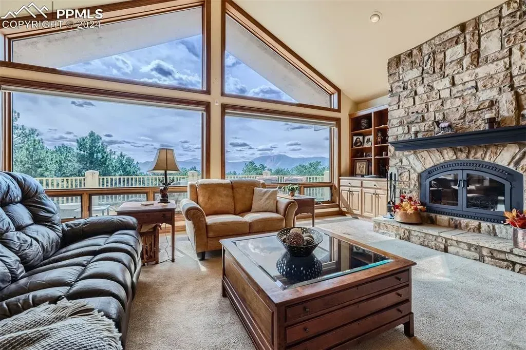A living room with a couch , chairs , coffee table and fireplace.