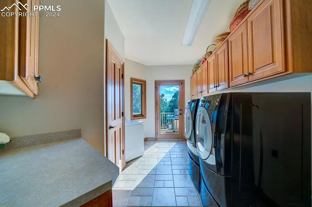 A laundry room with a washer and dryer and a refrigerator.