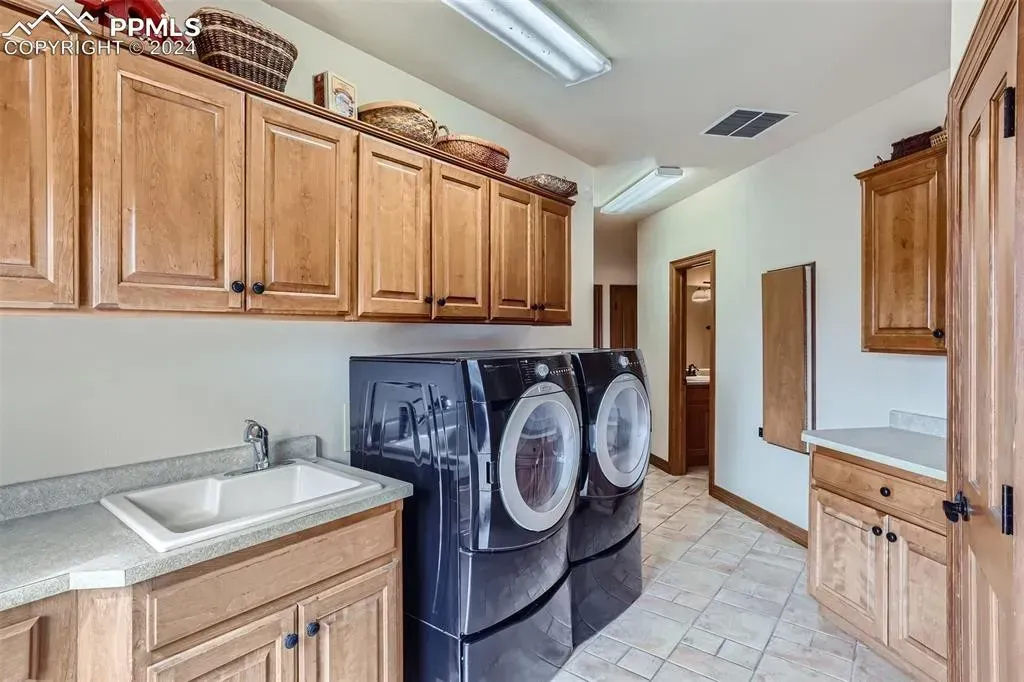 A laundry room with a washer and dryer and a sink