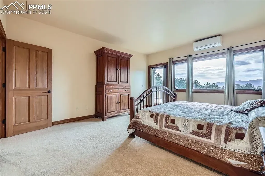 A bedroom with a large bed and lots of windows