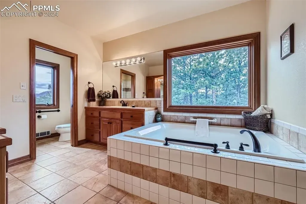 A bathroom with a large tub and a large window.