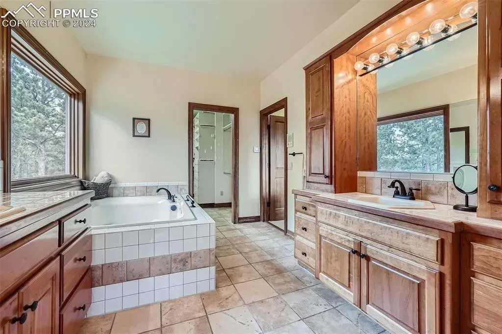 A bathroom with a large tub and two sinks
