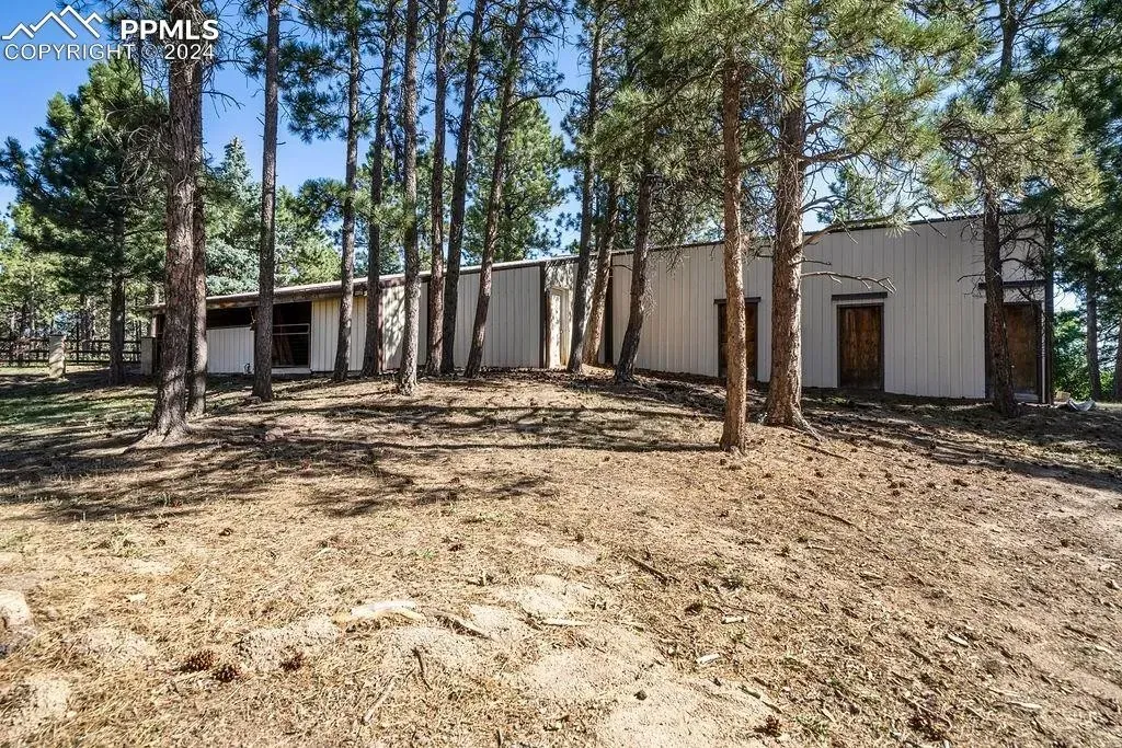 A house is sitting in the middle of a forest surrounded by trees.