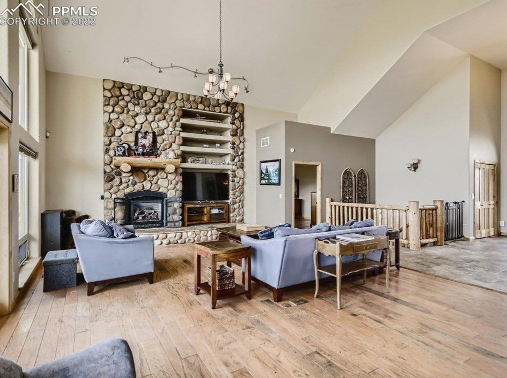 A living room with a couch , chairs , and a fireplace.