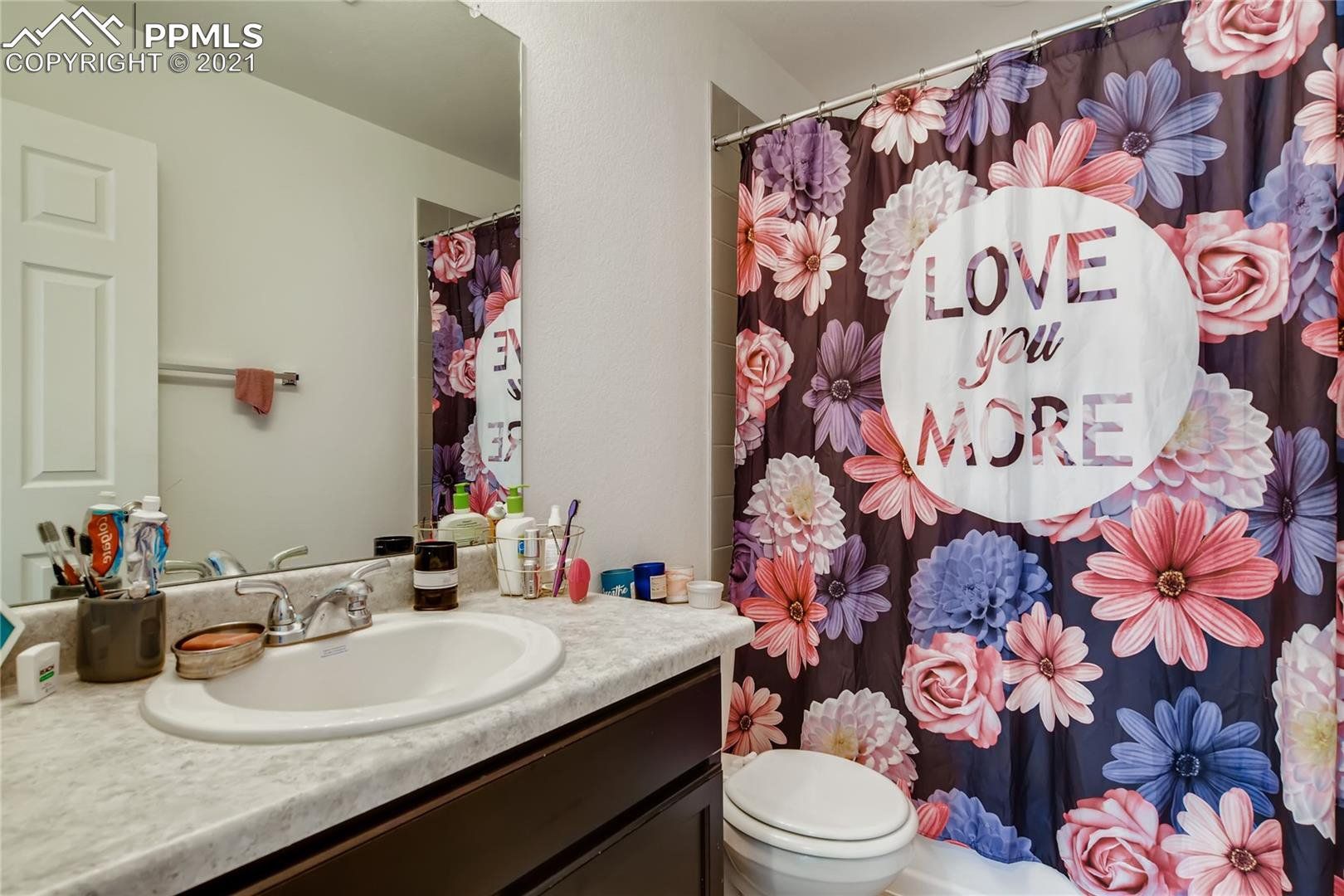 A bathroom with a shower curtain that says `` love you more ''