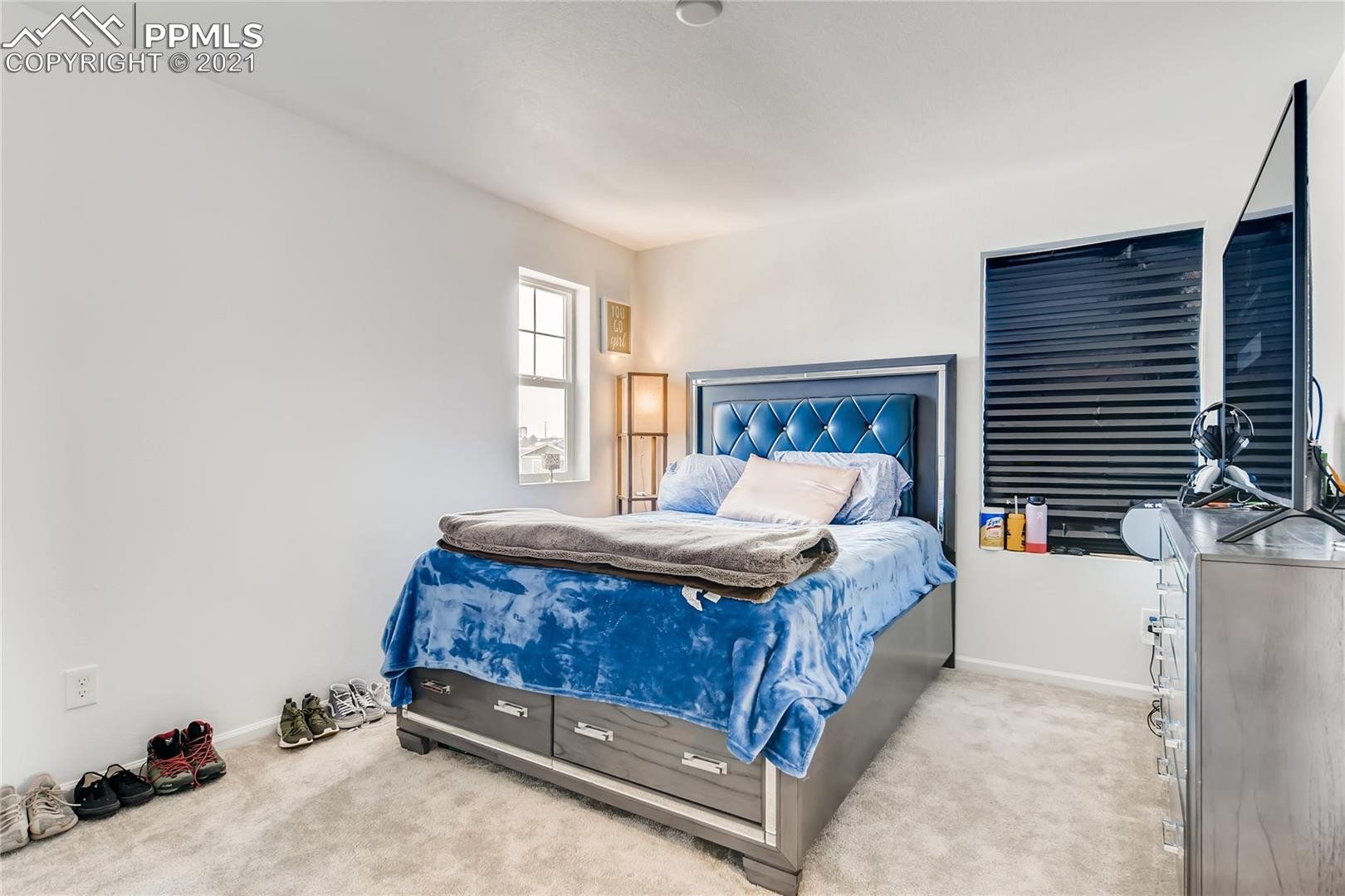 A bedroom with a bed , dresser , and television.