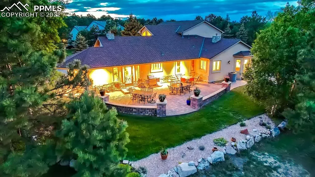 An aerial view of a large house with a patio at night.