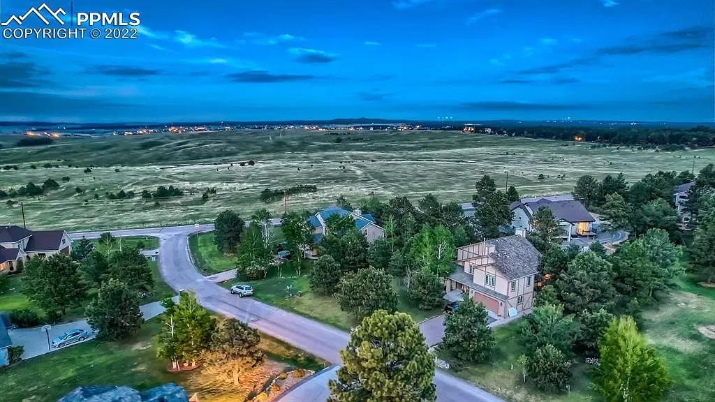An aerial view of a residential area with houses and trees at night.