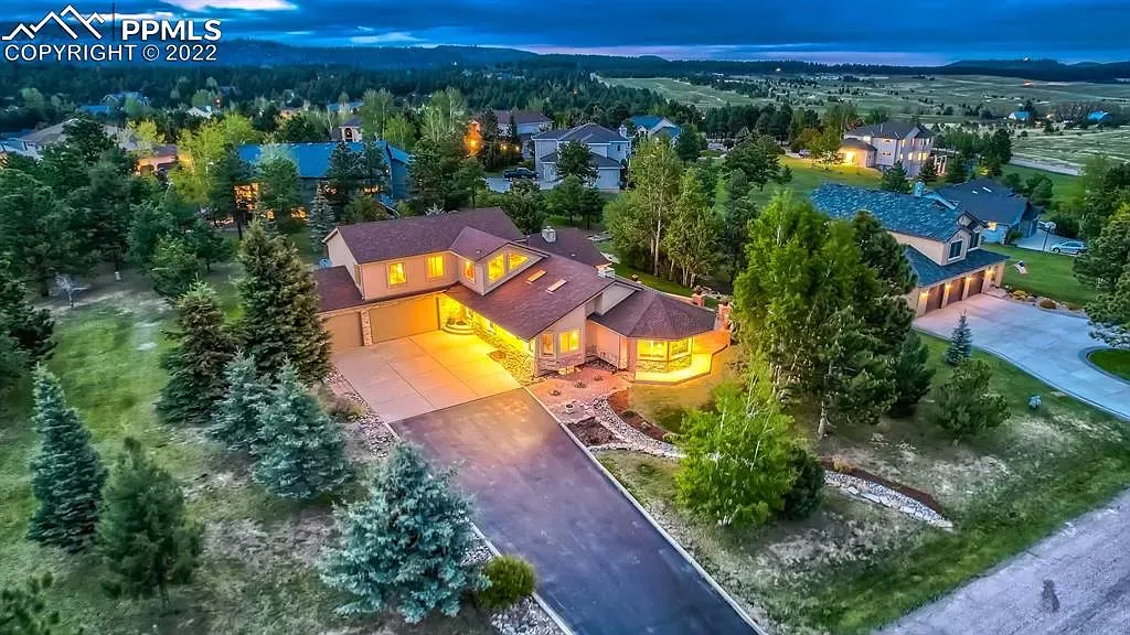 An aerial view of a large house surrounded by trees at night.