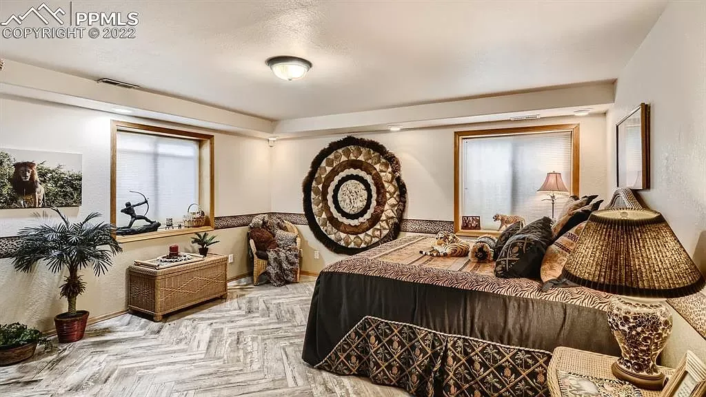 A bedroom with two beds and a rug on the wall.